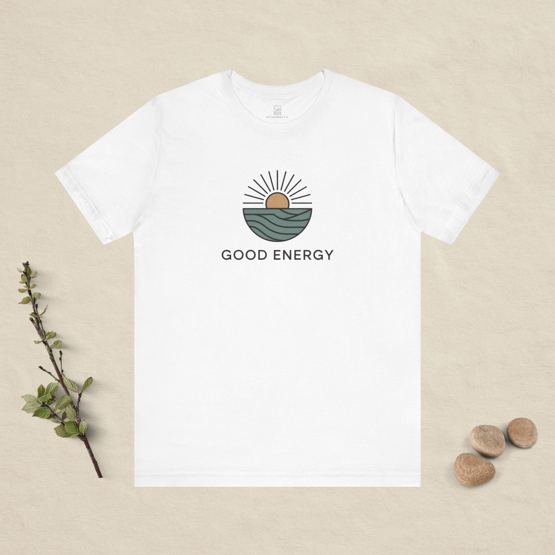 White t-shirt with 'Good Energy' design on a beige background