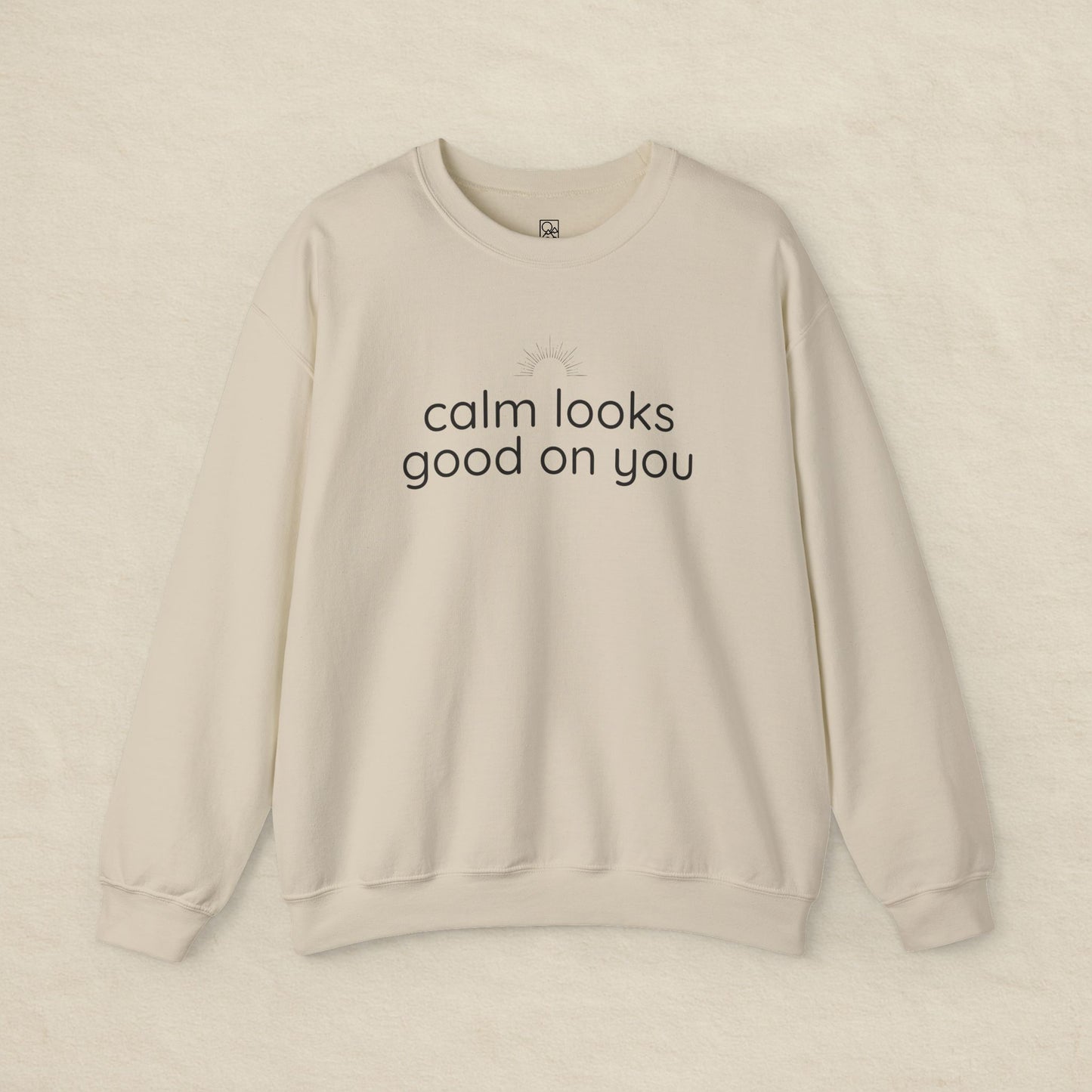 Beige sweatshirt with 'calm looks good on you' text on a beige background
