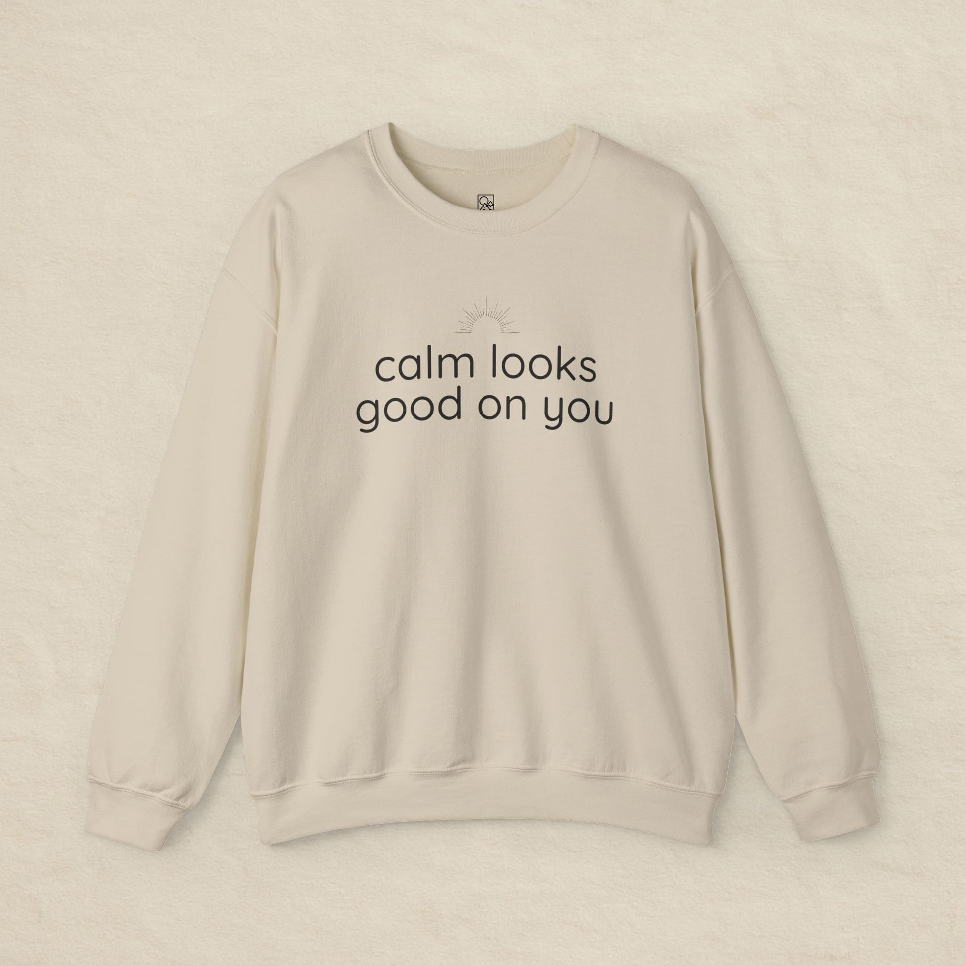 Beige sweatshirt with 'calm looks good on you' text on a beige background