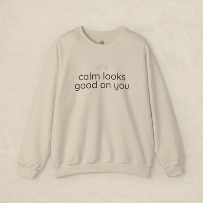 Beige sweatshirt with 'calm looks good on you' text on a beige background