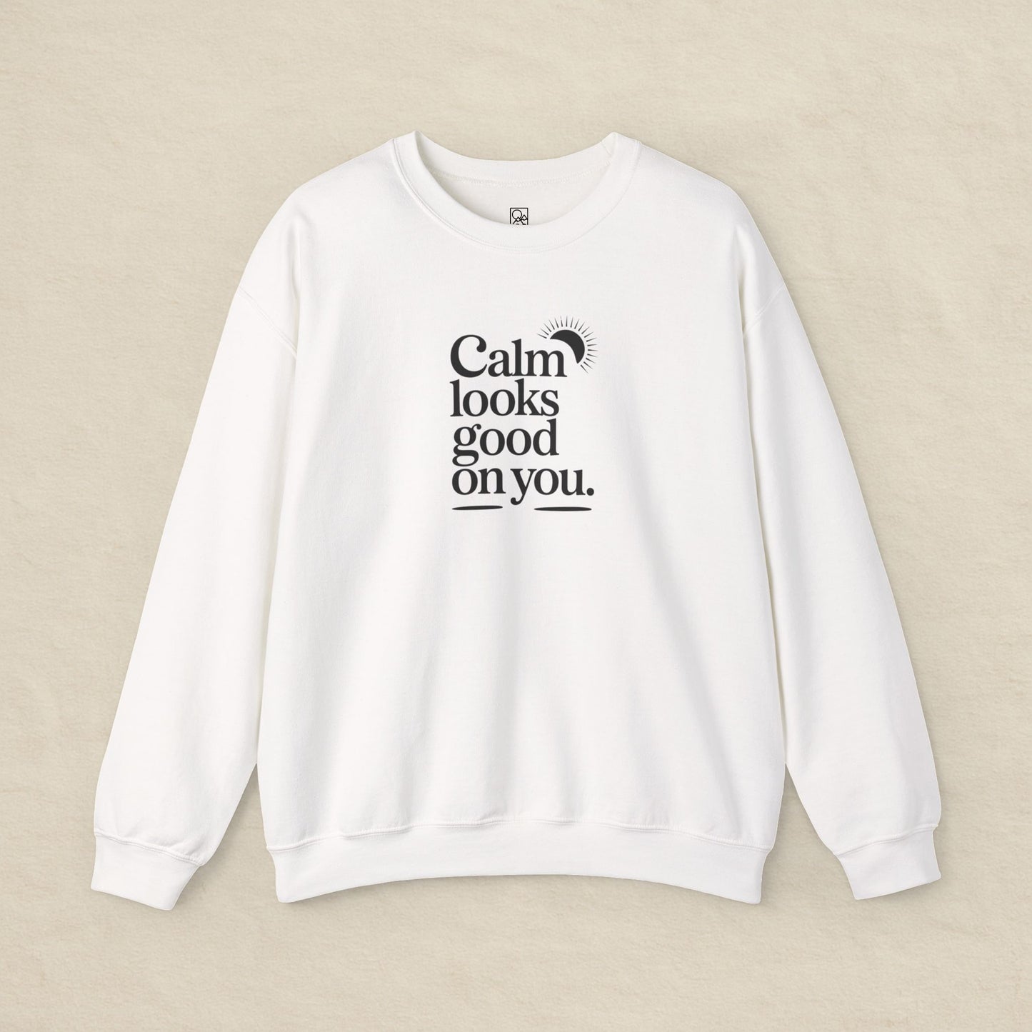 White sweatshirt with text 'Calm looks good on you' on a beige background