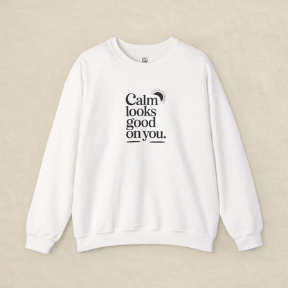 White sweatshirt with text 'Calm looks good on you' on a beige background